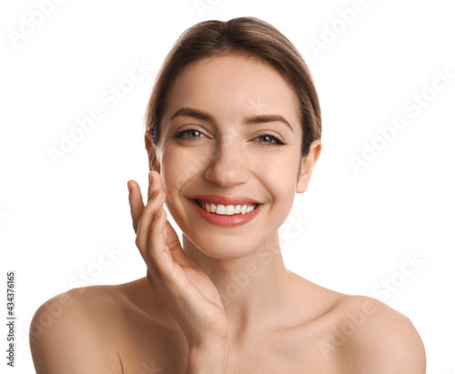 Young woman applying facial cream on white background