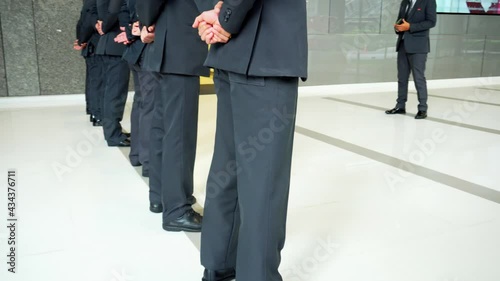 Video shot of security officer stand in line at meeting.