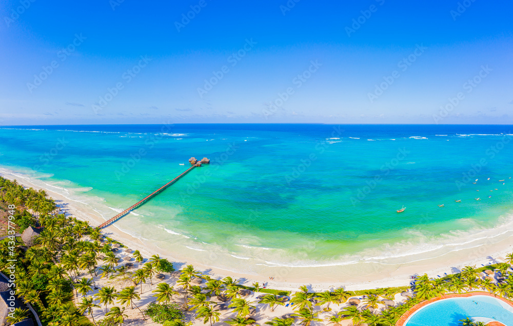 Aerial shot of the Stilt hut with palm thatch roof washed with turquoise Indian ocean waves on the white sand sandbank beach on Zanzibar island, Tanzania. Aerial shot of the Stilt hut with palm thatch roof washed with turquoise Indian ocean waves on the white sand sandbank beach on Zanzibar island, Tanzania.