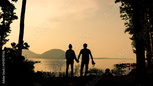 Silhouette of a traveller couple standing in nature