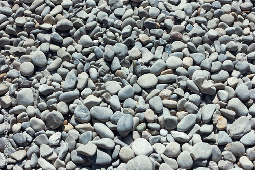 Closeup pebbles on the beach by the see or ocean. Natural background concept. High quality photo
