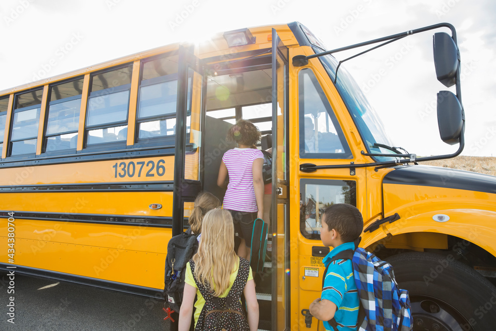 Schoolchildren boarding school bus going for field trip Stock Photo