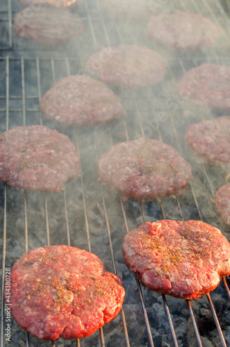 The hamburger meat is fried on the grill rack in the open air