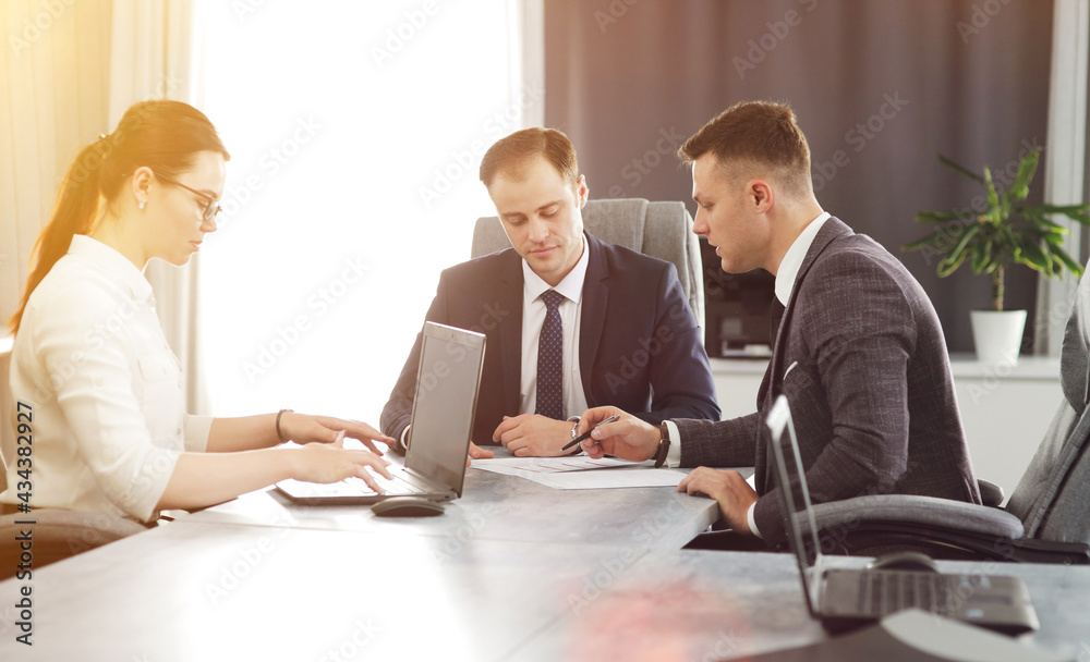 Group of young successful businessmen lawyers communicating together in a conference room while working on a project Group of young successful businessmen lawyers communicating together in a conference room while working on a project