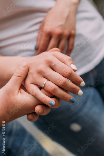man holds the hand of his beloved with a wedding ring on his finger © Екатерина Шелудько