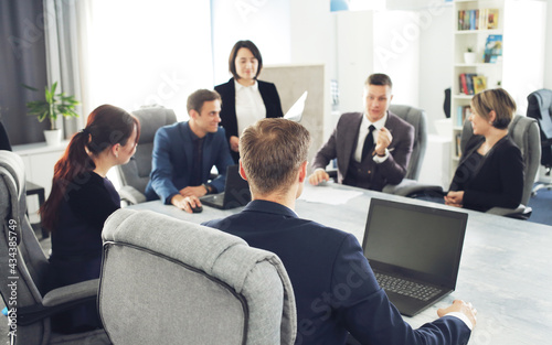 Group of young successful businessmen lawyers communicating together in a conference room while working on a project