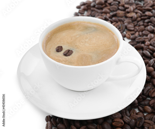 Cup with aromatic coffee and pile of beans on white background
