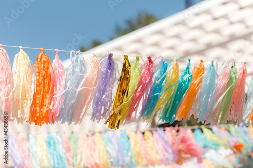 Multicolored garlands fringe with tassels on a summer beach playground. Summer background