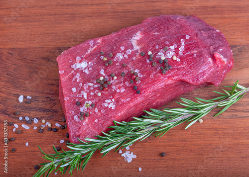 beef with rosemar and spicery on wooden background