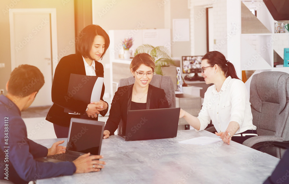 Three young successful business women in the office working together on a project