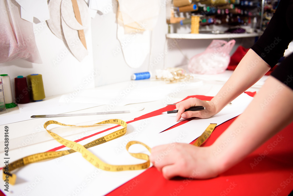 Fototapeta premium Tailor working with cloth at table in atelier.