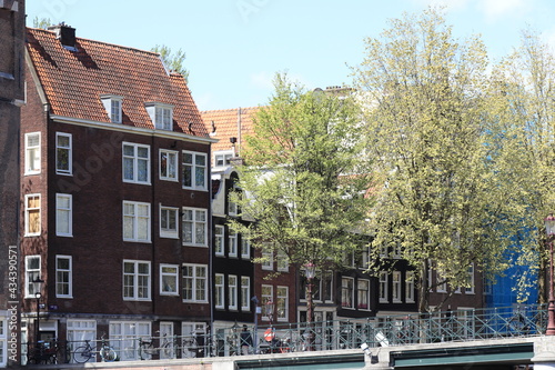 Canvas Print Amsterdam Oude Waal Canal Bridge View with Traditional Buildings and Green Trees