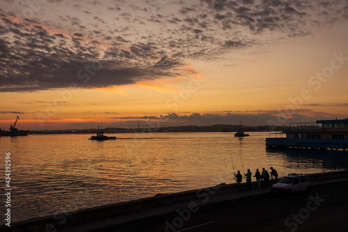 People fishing on Malecon street at sunrise in Havana, Cuba