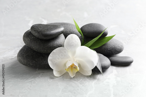 Spa stones  beautiful orchid flower and bamboo sprout on light grey table