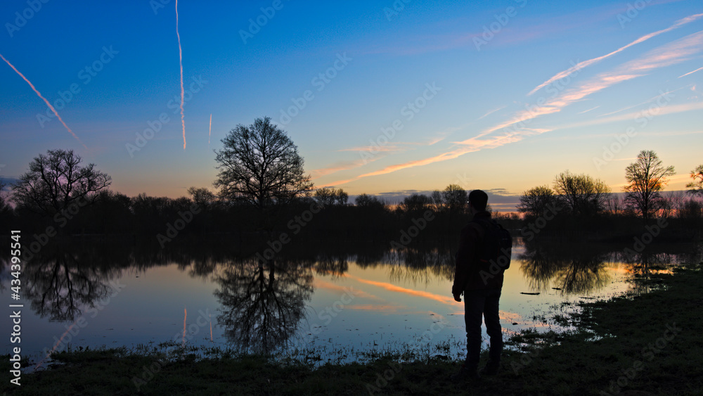 Fototapeta premium Lever de soleil sur les marais inondés de Bazouges-Cré sur Loir avec présence d'une silhouette