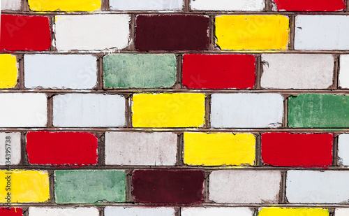 Colorful bricks wall close-up. Bright yellow, red, white and green bricks wall. Different colors - diversity concept. photo