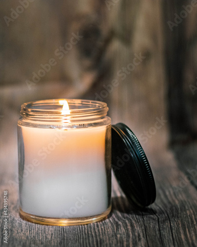 Photo farmhouse candle with wooden background and fire flame