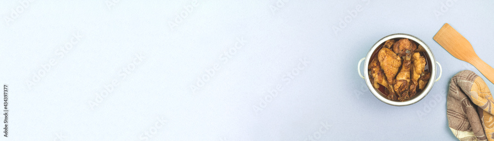 Wide banner kitchen background with saucepan and roasted chicken, towerl and wooden spoon, top view and flat lay background with copy space Wide banner kitchen background with saucepan and roasted chicken, towerl and wooden spoon, top view and flat lay background with copy space