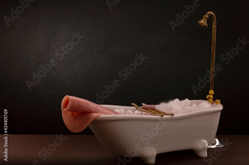 Tableau sur toile Jamon de cerdo y pavo en rebanada tomando baño en tina, concepto de carne fresca
