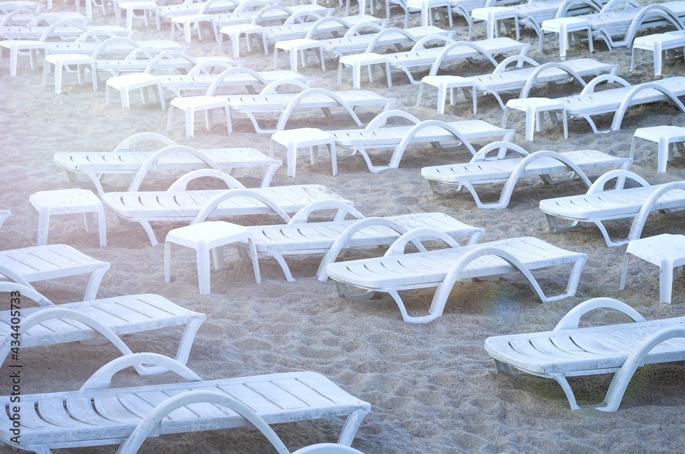 Summer chair.Beach Chaise Lounge Chair. Beach striped chaise-longues standing on sand by the sea. Beach season. Summer seashore.