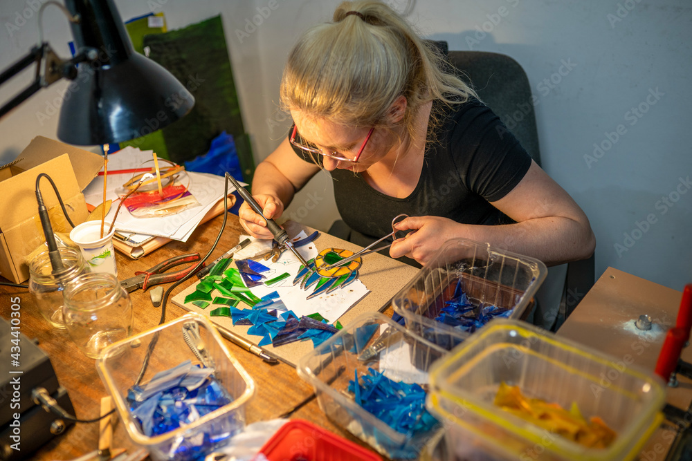 soldering the stained glass window, woman is making a stained glass, soldering the stained glass window