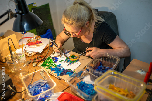 soldering the stained glass window, woman is making a stained glass, soldering the stained glass window