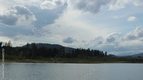 Lake and public beach near Svit, Slovakia. Spring windy day. Green forest in background.