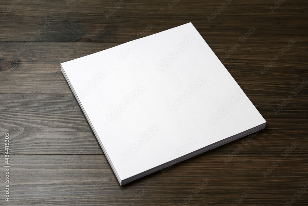 Stack of blank paper sheets on wooden table. Brochure design Stack of blank paper sheets on wooden table. Brochure design
