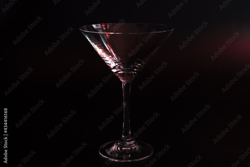 Empty Glass Clear Martini Glass with Red Tint on Black Background Empty Glass Clear Martini Glass with Red Tint on Black Background