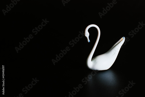Fototapeta Naklejka Na Ścianę i Meble -  Porcelain figurine of a white swan on a black background