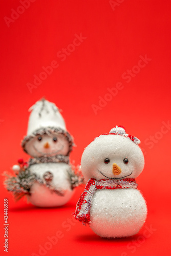 Snowman, Christmas snowman on a red background for a postcard. Merry christmas or happy new year greeting, place for text. Vertical photo. © SERSOLL
