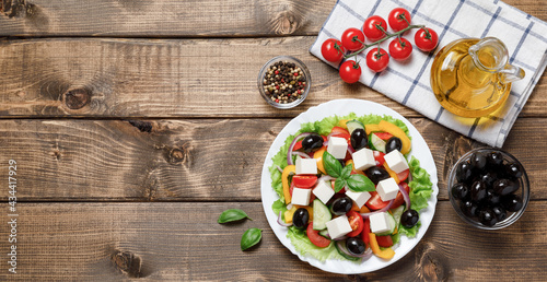 Healthy Greek Vegetables Salad with cheese on wooden background. Healthy food with fresh vegetables for dinner. Mediterranean cuisine. Top view, flat lay, banner, copy space