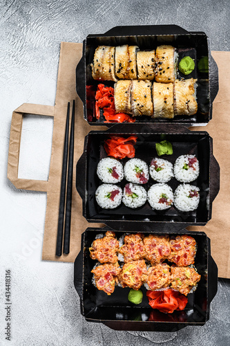 The sushi rolls in the delivery package, ordered in sushi take-out restaurant. Gray background. Top view