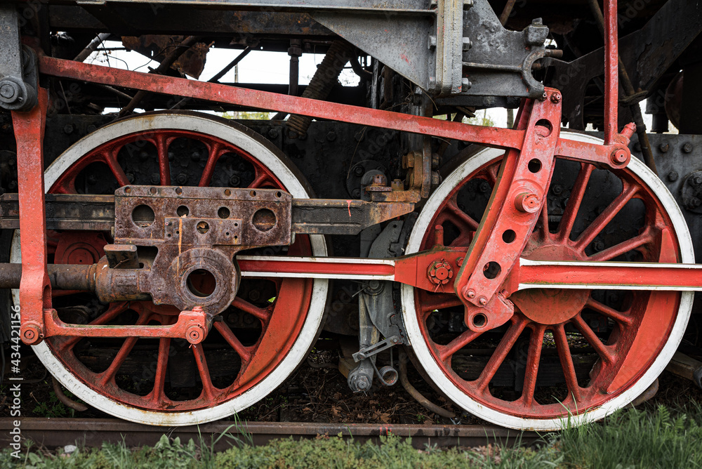 The wheels of an old vintage locomotive repainted in red and white
