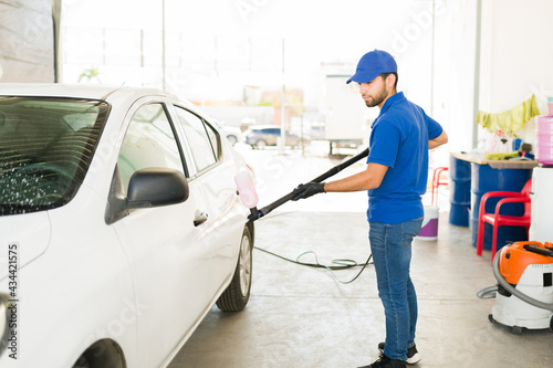 Latin man busy at the auto detail service