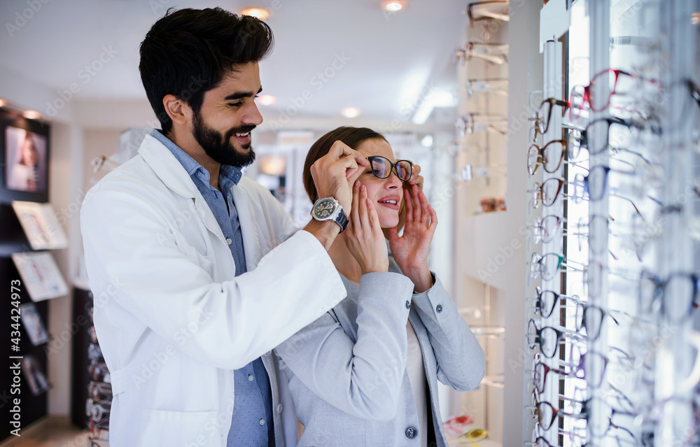 Young woman in optic store choosing a new glasses. Medical, health care concept