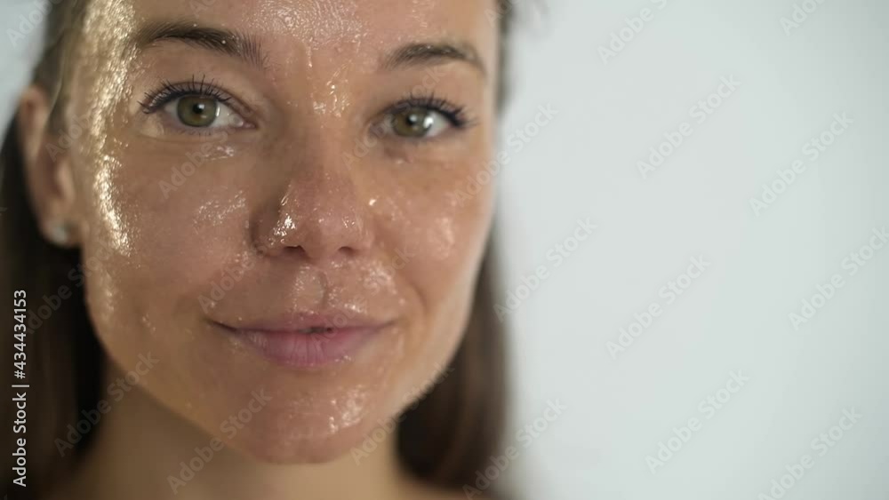 A young beautiful girl applies a transparent moisturizing mask to her face. A young beautiful girl applies a transparent moisturizing mask to her face.