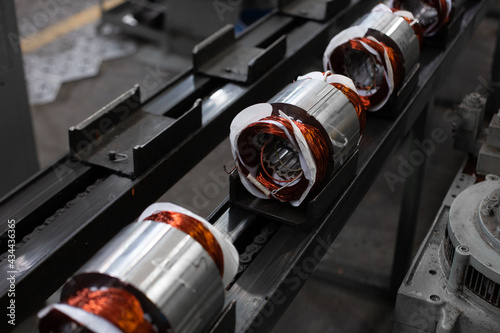 electric motors manufacture in industrial company - stators on assembly line of Semi-automated manual production. 20th century technology, obsolete factory processes concept.