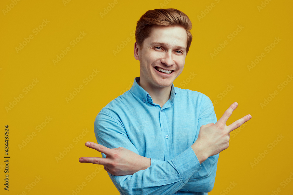 Young man dressed in blue shirt showing peace gesture with crossed hands Young man dressed in blue shirt showing peace gesture with crossed hands
