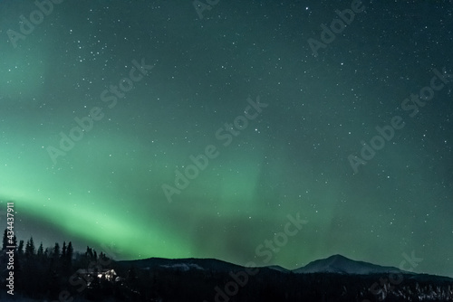 Foto Mountain view landscape in northern Canada with aurora borealis seen northern lights dancing in green sky