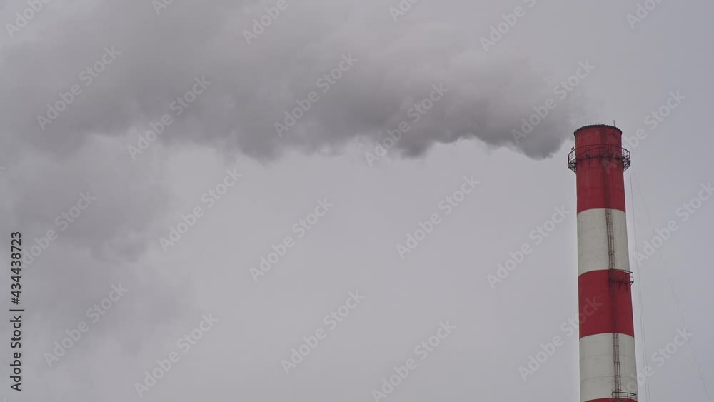 Working industrial pipe, against a gray sky, air pollution Working industrial pipe, against a gray sky, air pollution