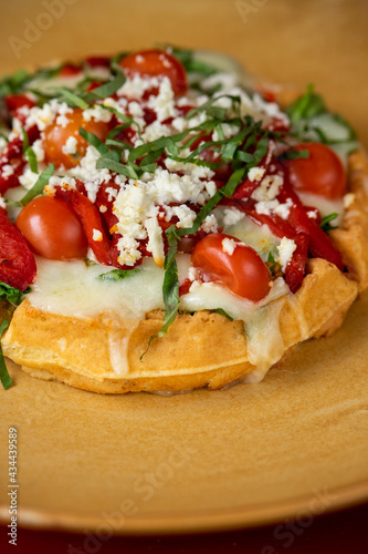 Waffle with tomato, basil, mozzarella, roasted bell peppers, and feta cheese.