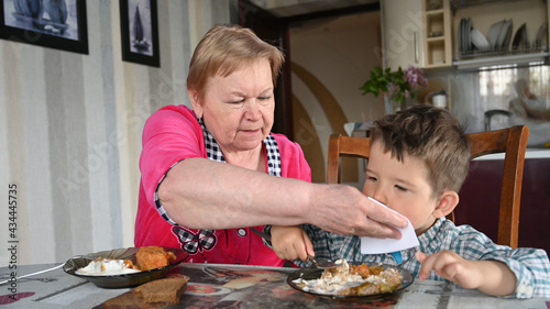 Caring grandmother with her grandson eat