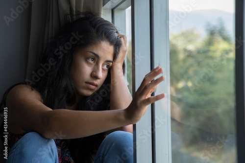 Foto Mujer triste en la ventana