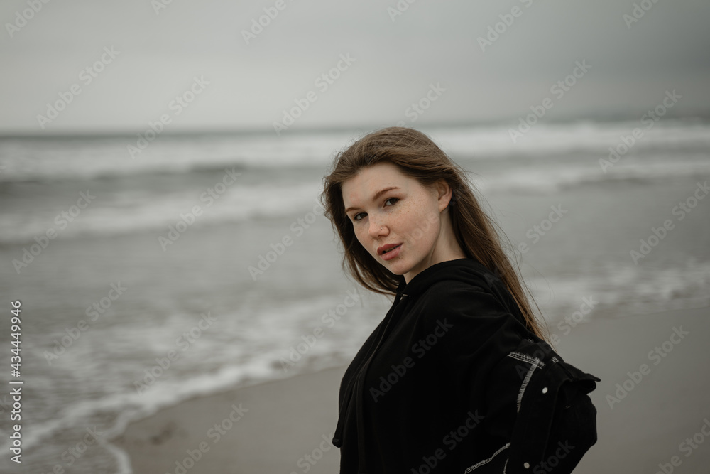 young girl stands on the shore with freckles and long hair, stinking sea young girl stands on the shore with freckles and long hair, stinking sea