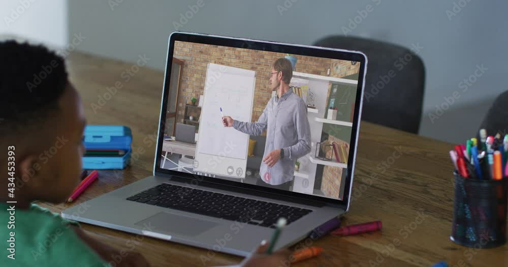 African american boy having a video call on laptop while doing homework at home African american boy having a video call on laptop while doing homework at home