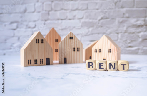 Miniature house and wooden blocks with the word rent on marble table.Real estate concept.Rent apartment. Property. Rental, renting home. Buying. Purchase housing