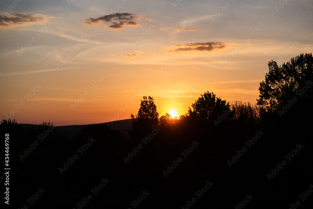 The sun sets behind the mountains during spring. The sun sets behind the mountains during spring.