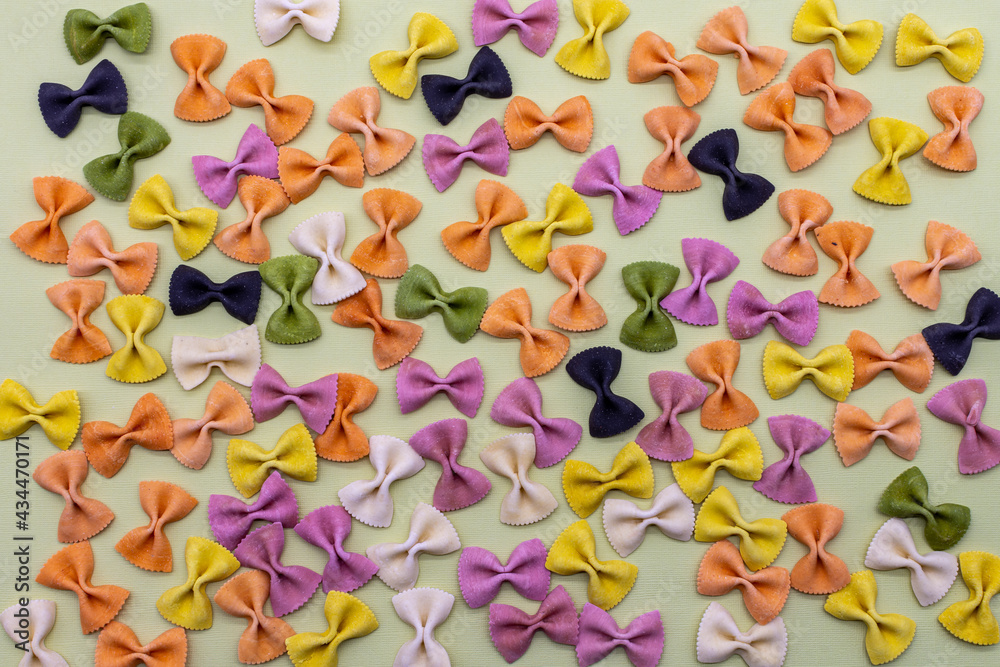 Colorful Italian pasta background. Various colors of bow tie farfalle pasta. Top view. Selective focus.