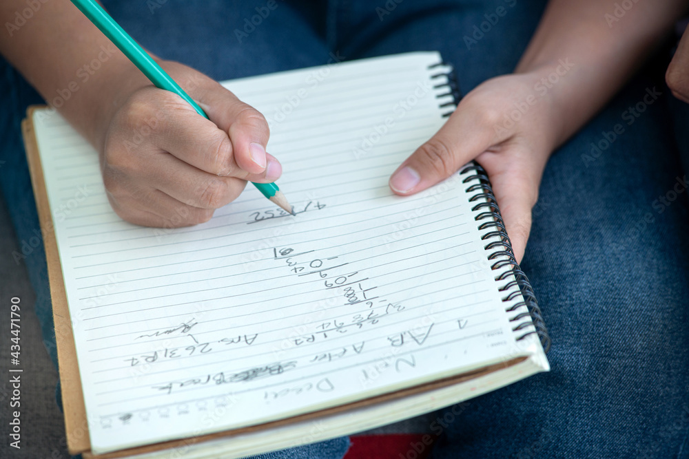 Close up, Asian boy doing math homework, educating at home